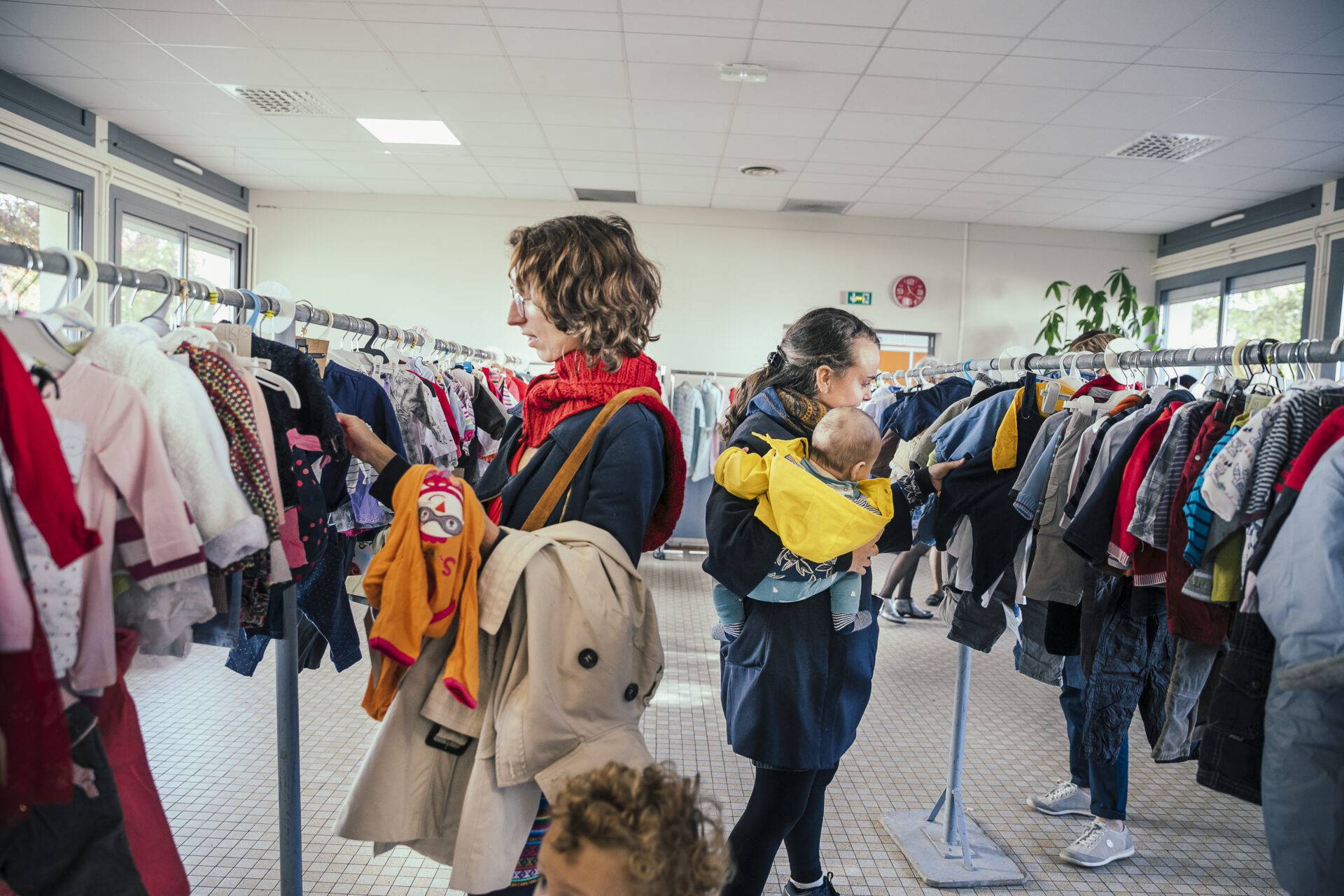 Image d'illustration de deux femmes cherchant des vêtements pour enfants à la bourse du Centre Social.